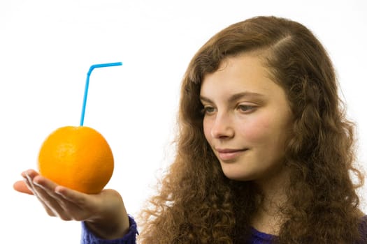 Eine junge hübsche Frau hält eine Orange mit Strohhalm in der Hand