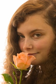 A young beautiful woman holds a rose in her hand