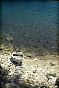 Vintage photo of lonely boat in a beautiful clear water lagoon