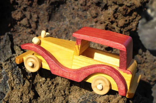 Transportation Concept Wooden Toy Car on the Rocks