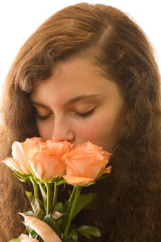 A young pretty woman holds a bouquet of roses in her hand and smells it