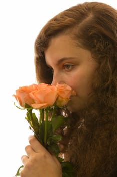 A young pretty woman holds a bouquet of roses in her hand and smells it