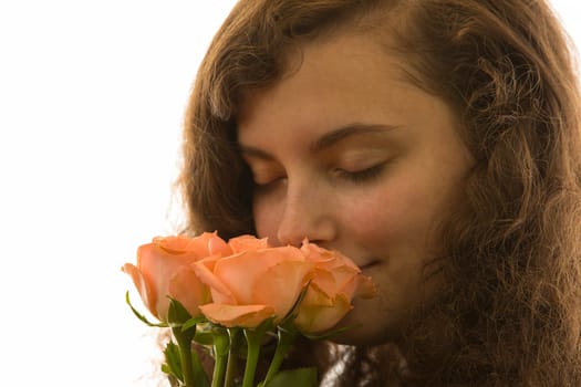 A young pretty woman holds a bouquet of roses in her hand and smells it