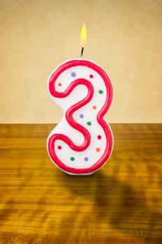 Burning birthday candle number 3