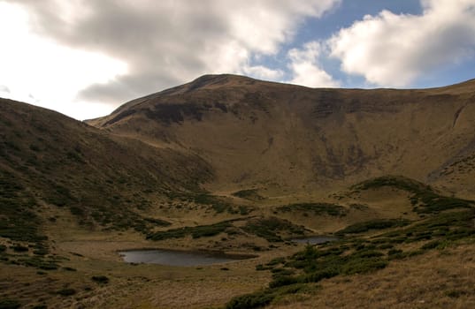 Oval lake at the foot of the mountain