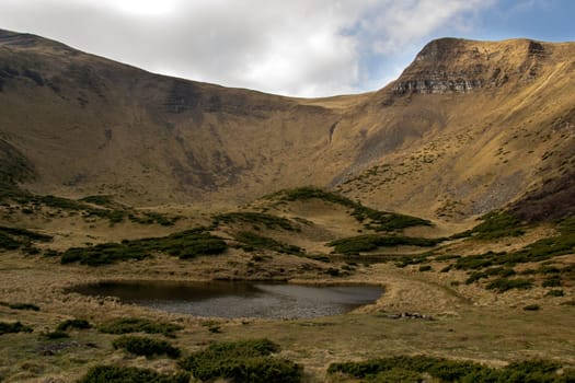 Oval lake at the foot of the mountain