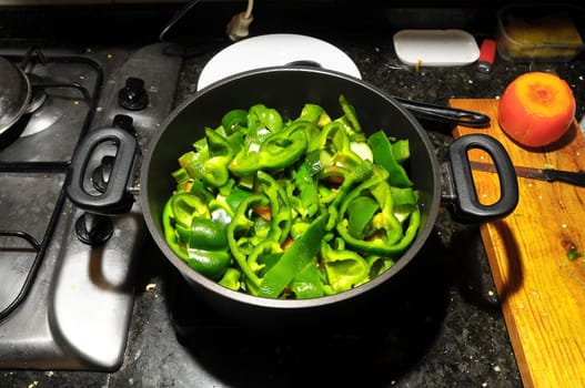 Coocking Green Chili Pepperson a Black Pot