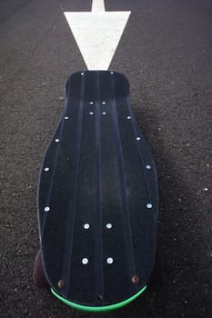 Vintage Style Longboard Black Skateboard on an Empty Asphalt Desert Road