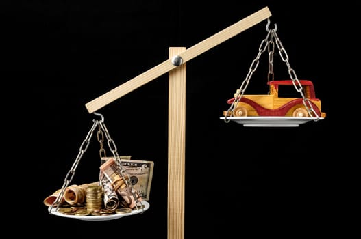 Money and Toy Wooden Car on a Two Pan Balance