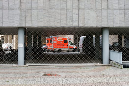 Frankfurt,Germany – February 19,2014: An ambulance of the Arbeiter Samariter Bund behind the bars of a fire brigade entrance on February 19,2014 in Frankfurt.