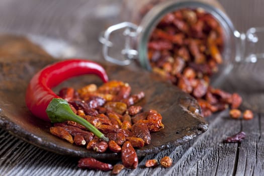 Chili peppers on wooden shovel and in storage jar