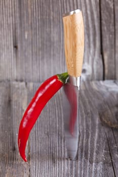 Thai chili leaning on sharp knife
