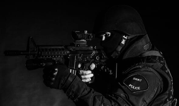 Special weapons and tactics (SWAT) team officer on black background
