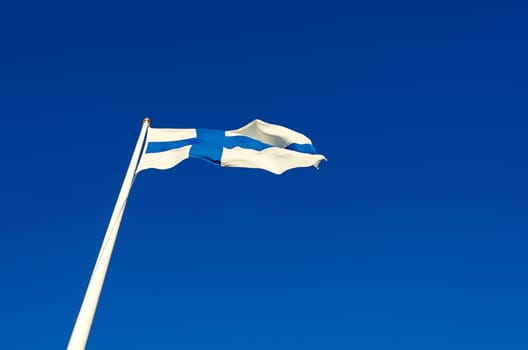 Finnish flag against a blue summer sky on a sunny day