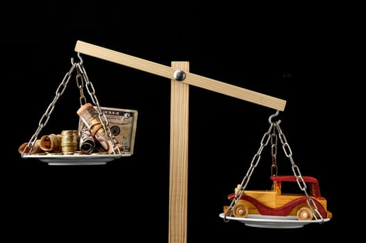 Money and Toy Wooden Car on a Two Pan Balance