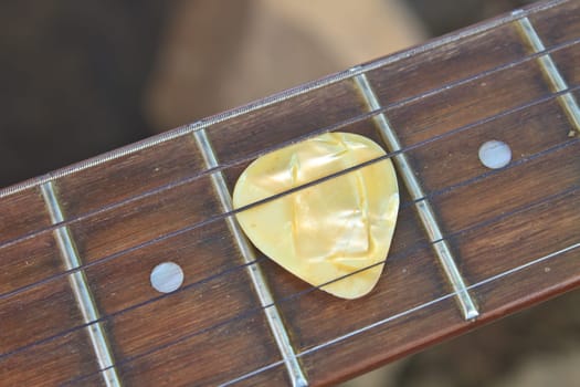 guitar pick on the fingerboard close up