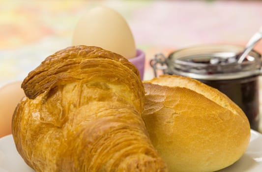 Breakfast with rolls,croissant,egg and jam