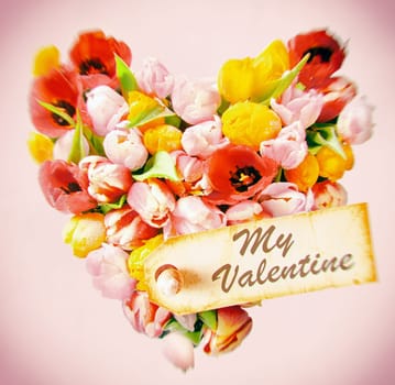 Tender feminine Valentines greeting card with a - My Valentine - gift tag on a heart of colourful decorative fresh tulips on a square pink background with vignetting