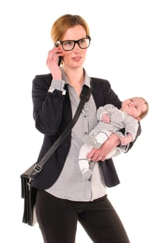 Adult businesswoman woman wears shirt and jacket and has an infant in her arms while talking on her cell phone,exempted against a white background.