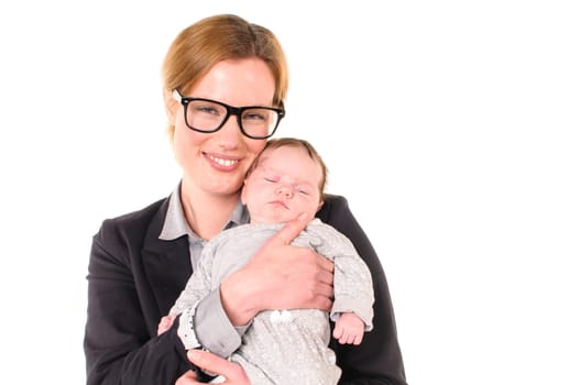 Adult businesswoman woman wears shirt and jacket and laughingly holds an infant in her arms,exposed against a white background.
