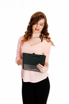 A young pretty woman standing in black tights and a pink blouse for white.background writing on her clipboard..