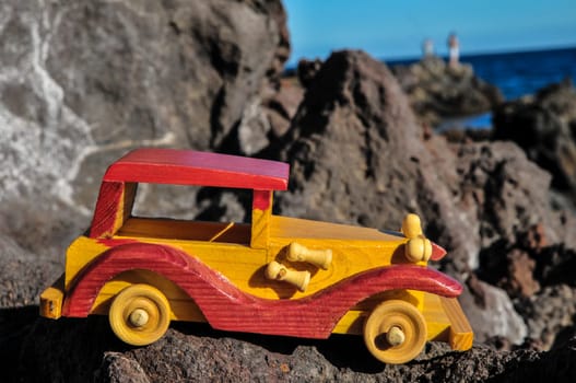 Transportation Concept Wooden Toy Car on the Rocks