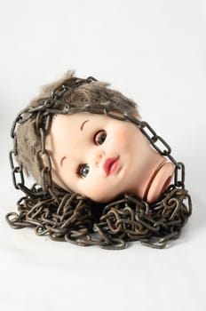Vintage Plastic Scary Doll Head and Chain on a White Background