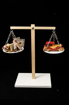 Money and Toy Wooden Car on a Two Pan Balance