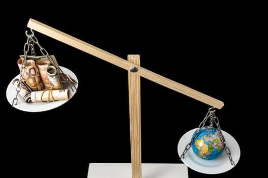 Globe Planet Earth and Money on a Two Pan Balance