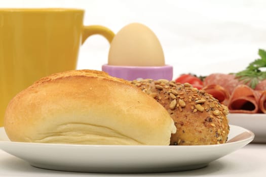 Cut-out of a breakfast table with rolls,cold cuts,egg and coffee cup