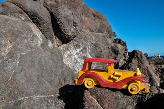 Transportation Concept Wooden Toy Car on the Rocks