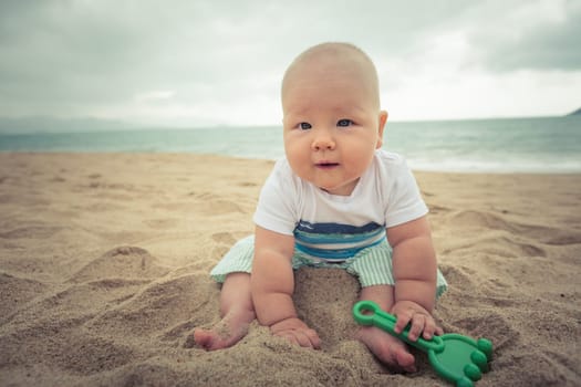 Cute baby sitting on a sand