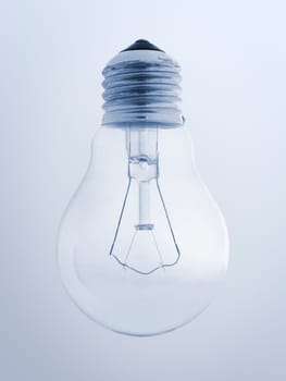 Close-up of a single crystal-clear household light bulb with screw thread on a light blue gradient background
