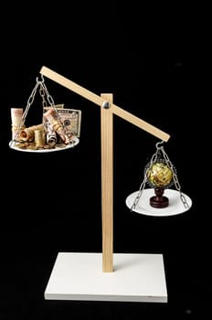 Globe Planet Earth and Money on a Two Pan Balance
