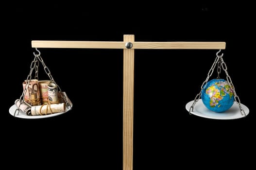 Globe Planet Earth and Money on a Two Pan Balance