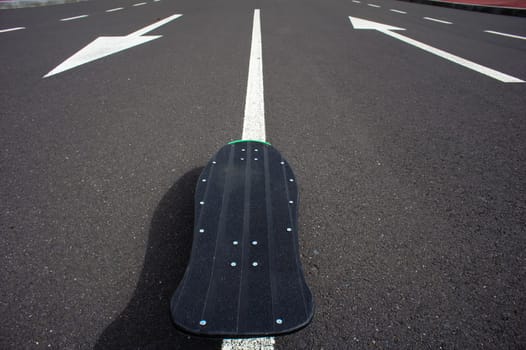 Vintage Style Longboard Black Skateboard on an Empty Asphalt Desert Road