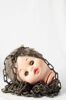 Vintage Plastic Scary Doll Head and Chain on a White Background