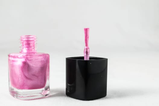 Colorful nail polish brush over white background