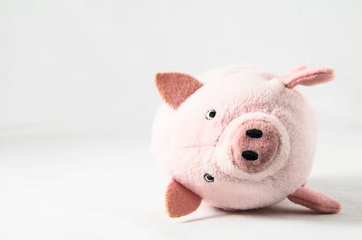 The pink pig cloth figurine on a white background