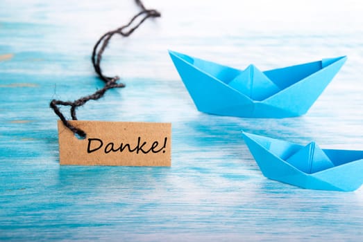 The German Word Danke Which Means Thanks on a Tag with a Boat Background