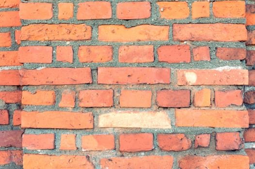 Old red brick wall fragment as a background texture
