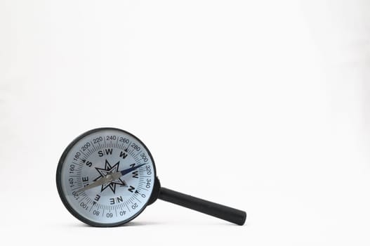 Orientation Concept - Analogic Compass and Loupe on a White Background
