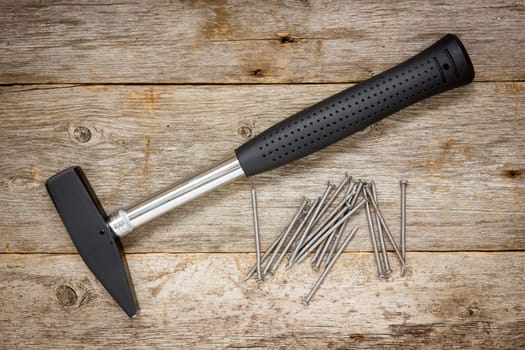 Hammer and nails on the wooden background