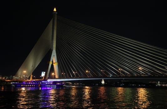 The Saphan Phra Ram 8 Brueckein the night at the Menam Chao Phraya River in the center of the capital Bangkok in Thailand.