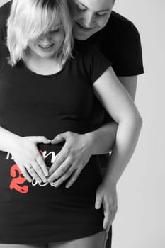 Happy young pregnant couple in the studio