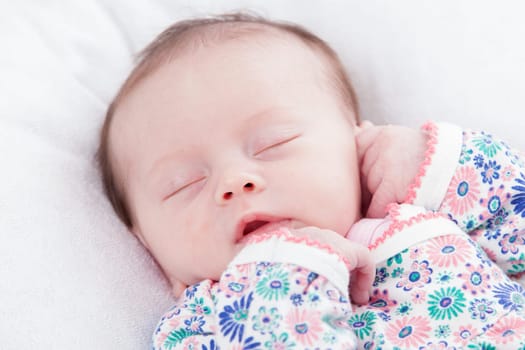 happy newborn baby girl just a week old photographed in the studio