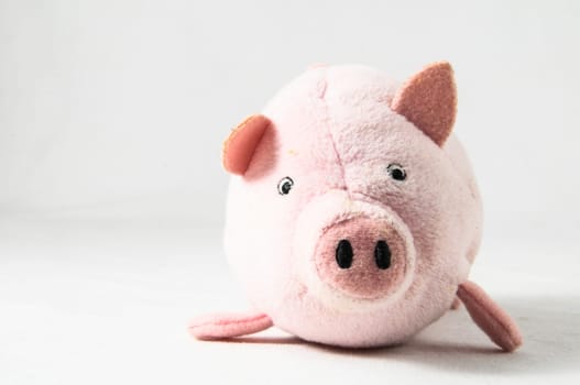 The pink pig cloth figurine on a white background