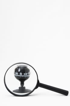 Orientation Concept - Analogic Compass and Loupe on a White Background