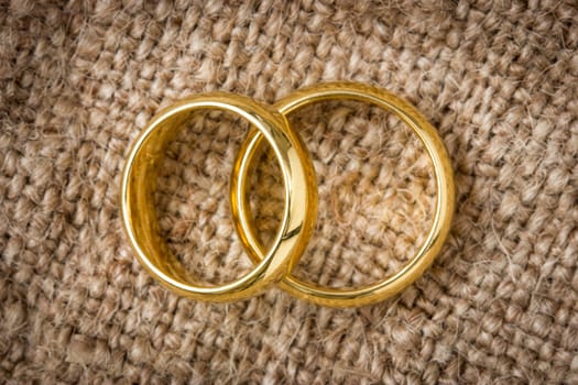 Two golden  rings on the burlap background