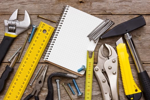 Work tools and notebook on the wooden background